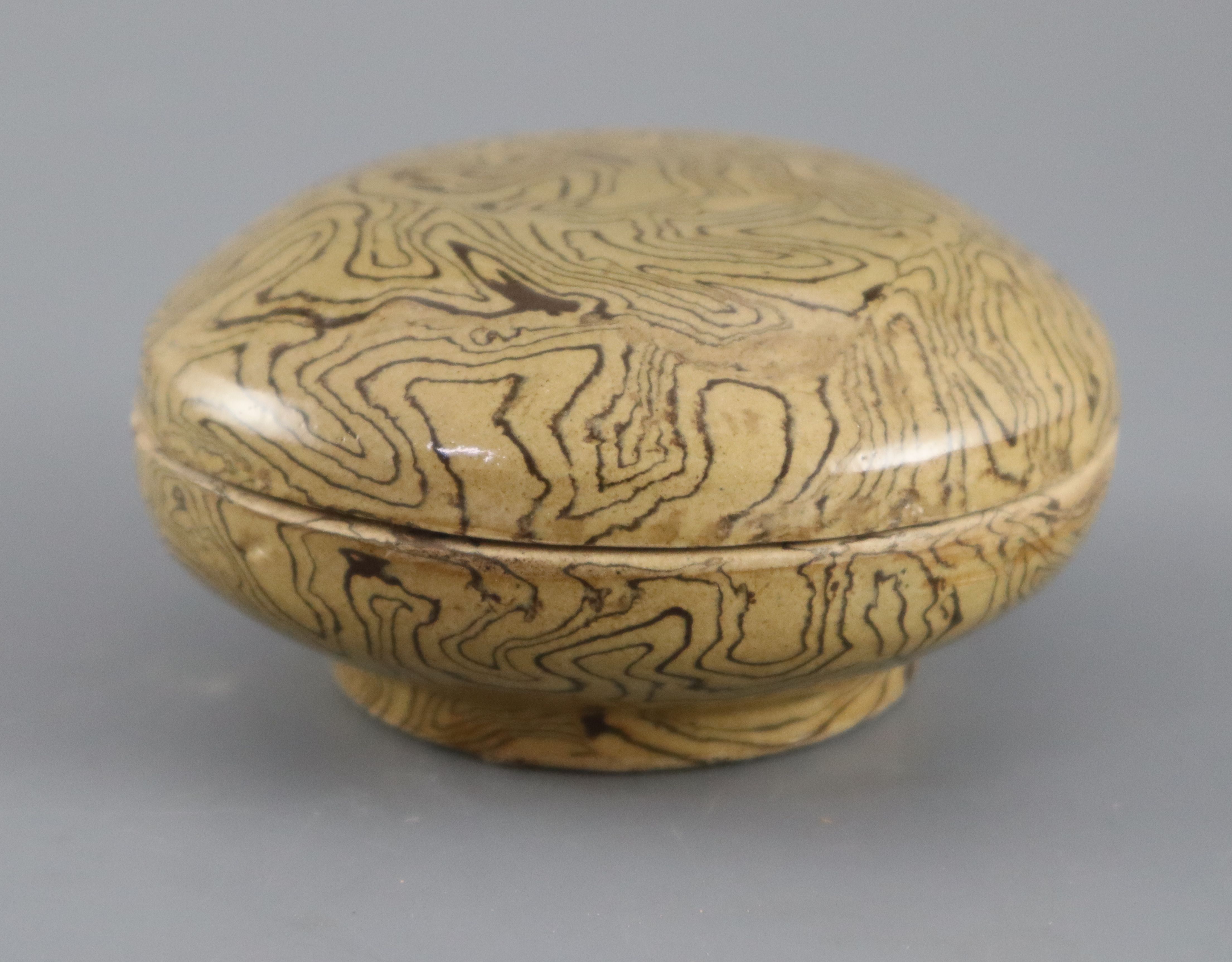 A Chinese marbled straw glazed box and cover, Tang dynasty or later, 11cm diameter